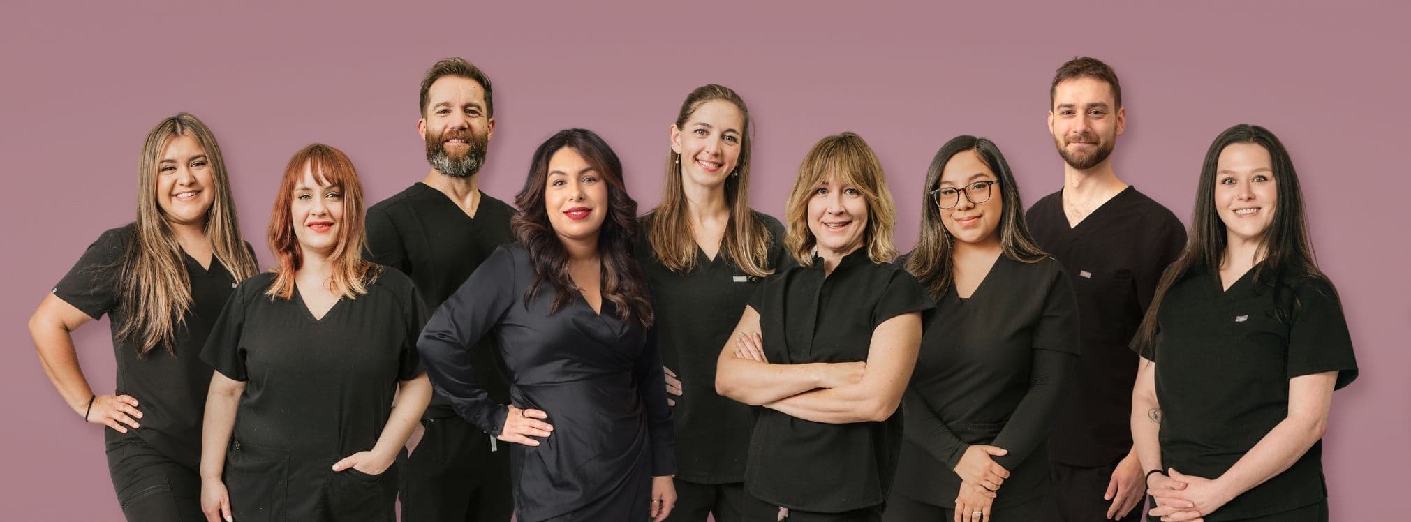 The D'Vida Wellness Clinic team: nine smiling practitioners and staff standing together.